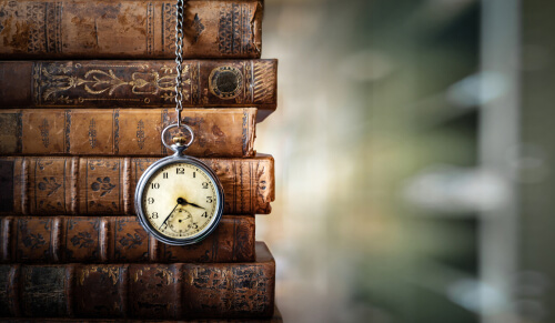 Livros e um relógio com o objetivo de simbolizar a linha do tempo para contar a história da SOS educação