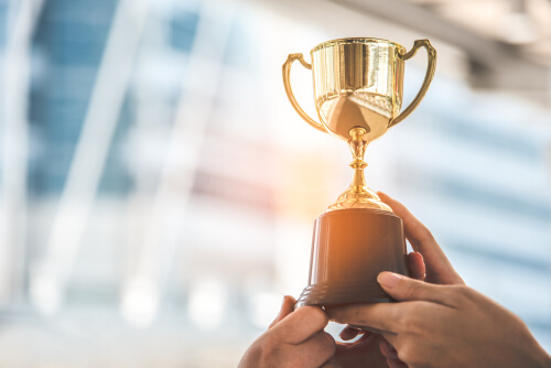 Pessoa com troféu levantado para simbolizar os prêmios que a SOS ganhou em sua existência